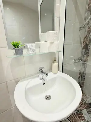 a white sink in a bathroom with a shower at Center Apartments The Quiet Luxury 5 in Plovdiv