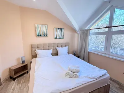 a bedroom with a large bed with two towels on it at Center Apartments The Quiet Luxury 5 in Plovdiv
