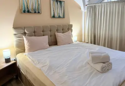 a bedroom with a large white bed with towels on it at Center Apartments The Quiet Luxury 5 in Plovdiv