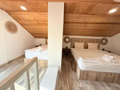 two beds in a room with wooden ceilings at Center Apartments The Quiet Luxury 6 in Plovdiv