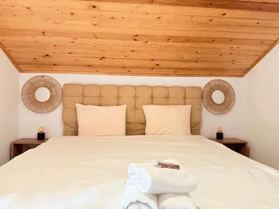a bedroom with a large white bed with wooden ceilings at Center Apartments The Quiet Luxury 6 in Plovdiv