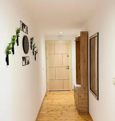 a hallway with white walls and wooden floors and a door at Center Apartments The Quiet Luxury 7 in Plovdiv