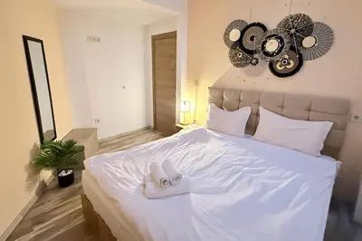 a bedroom with a large white bed with a fan at Center Apartments The Quiet Luxury 7 in Plovdiv