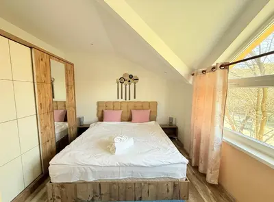 a bedroom with a bed with white sheets and pink pillows at Central 2 Bedroom Apartments The Quiet Luxury 8 in Plovdiv