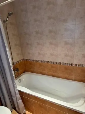 a white bath tub in a bathroom with a shower at Top location unique apartment in Bansko