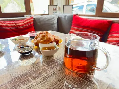 a glass mug of tea on a table with food at Стаи за гости Куцеви in Devin