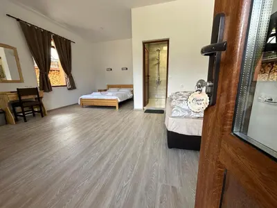 a room with a bed and a bedroom with a door at Стаи за гости Куцеви in Devin