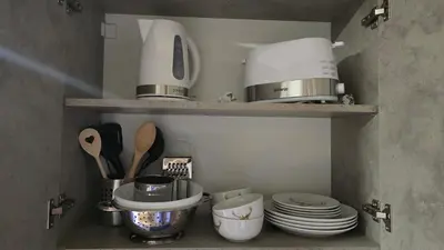 a kitchen with plates and utensils on shelves at Studio Todorka in Bansko