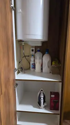 a cupboard filled with milk bottles and a sink at Studio Todorka in Bansko