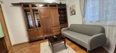 a living room with a chair and a cabinet at Venelin Apartment in Sofia
