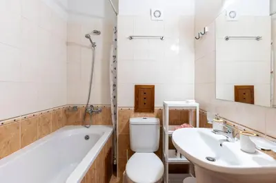a bathroom with a tub and a toilet and a sink at Pirin Golf & Country Club Apartment in Bansko