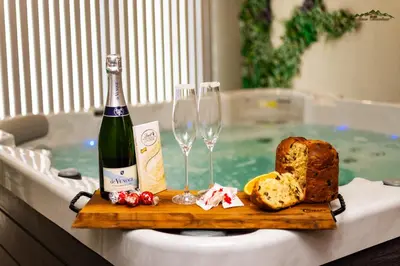 a bottle of wine and bread and wine glasses in a hot tub at Villa Malevitsa Вила Малевица in Relyovo