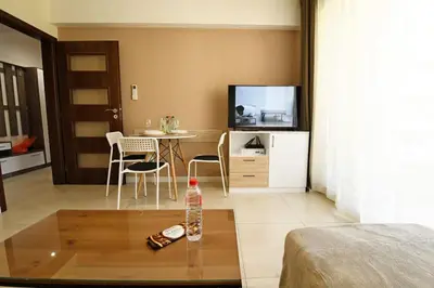 a living room with a table and a television at INB Banishora spot 9 in Sofia