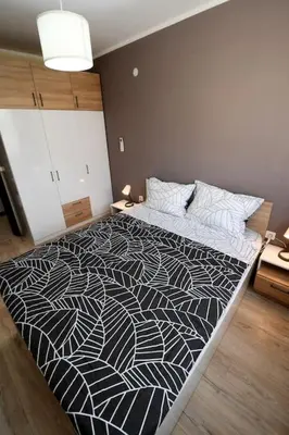 a bedroom with a large bed with a black and white comforter at INB Banishora spot 9 in Sofia