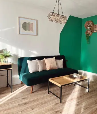 a living room with a green couch and a coffee table at Бутиков Семеен Хотел БРИО in Velingrad