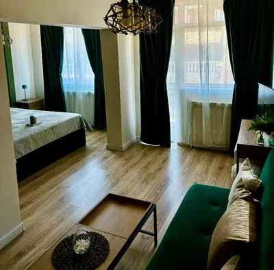 a living room with a couch and a table at Бутиков Семеен Хотел БРИО in Velingrad