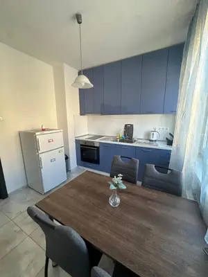 a kitchen with a wooden table and blue cabinets at Lions Bridge C-E-N-T-R-A-L in Sofia