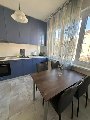 a kitchen with a wooden table and some chairs at Lions Bridge C-E-N-T-R-A-L in Sofia