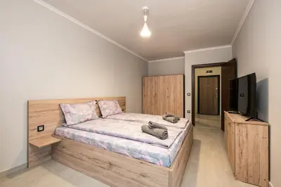 a bedroom with a bed and a flat screen tv at Комплекс Стадиона in Velingrad
