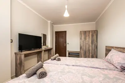 a bedroom with two beds and a flat screen tv at Комплекс Стадиона in Velingrad