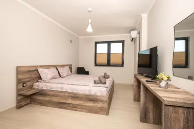 a bedroom with a bed and a flat screen tv at Комплекс Стадиона in Velingrad