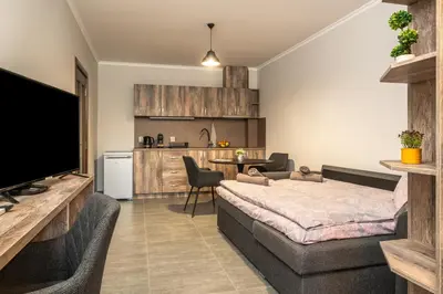 a living room with a bed and a kitchen at Комплекс Стадиона in Velingrad