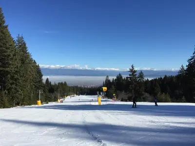a snow covered ski slope with people skiing on it at Belvedere 1Bedroom Apartment with Kitchen in Bansko