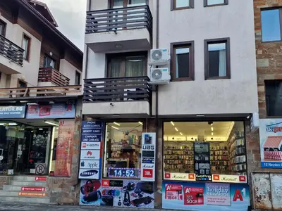 a store with signs in the windows of a building at Two-bedroom Apartment Paskalina, near the Ski lift in Bansko