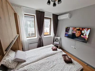 a bedroom with a bed and a tv on the wall at Two-bedroom Apartment Paskalina, near the Ski lift in Bansko