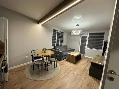 a living room with a table and chairs and a couch at Vimar Apartments in Panagyurishte
