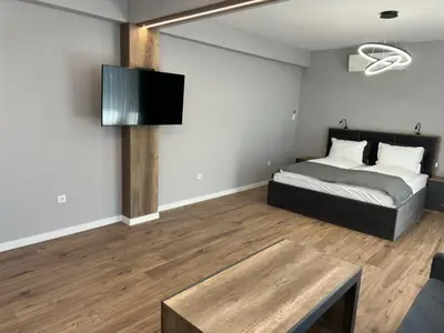 a bedroom with a bed and a flat screen tv at Vimar Apartments in Panagyurishte