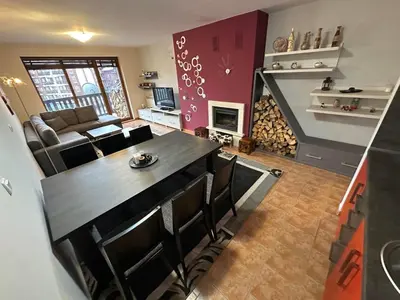 a kitchen and living room with a table and chairs at Penthouse 2 Bedroom Apartment w fireplace in Bansko