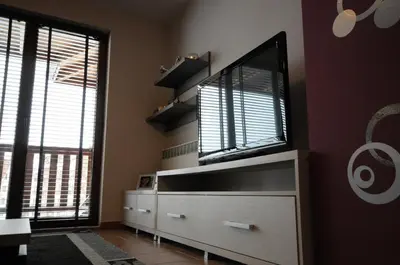 a living room with a flat screen tv on a dresser at Penthouse 2 Bedroom Apartment w fireplace in Bansko