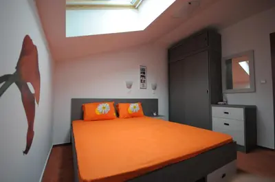 a bedroom with an orange bed and a skylight at Penthouse 2 Bedroom Apartment w fireplace in Bansko