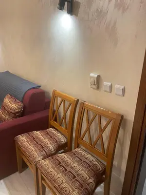 a room with two wooden chairs and a bed at English Apartments in Bansko