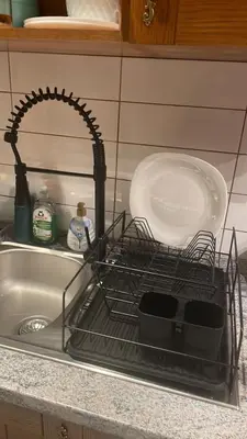 a dish drying rack in a sink with a plate at English Apartments in Bansko