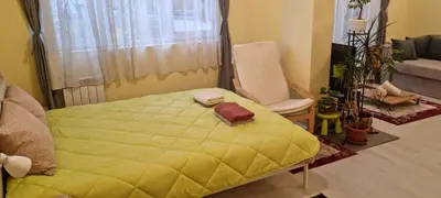 a bedroom with a yellow bed and a chair at Peaceful studio in the city center, close to subway, Medical University in Sofia