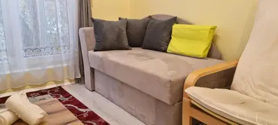 a couch with two pillows on it in a room at Peaceful studio in the city center, close to subway, Medical University in Sofia