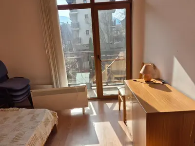 a bedroom with a bed and a desk and a window at Apartment Niko in Bansko