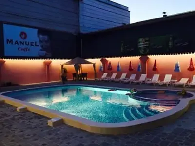 a large swimming pool with chairs and a building at Family Hotel Relax in Strelcha