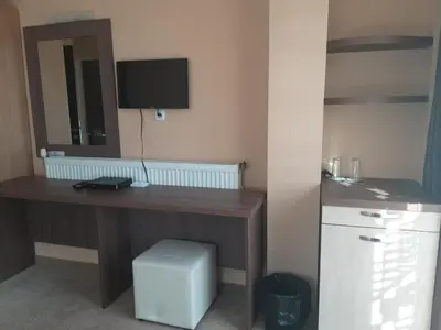 a room with a desk with a computer and a television at Family Hotel Relax in Strelcha