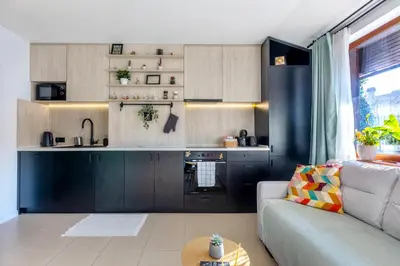a living room with a couch and a kitchen at The Snowmad Nest - Valentina Heights, 8 min from the gondola in Bansko