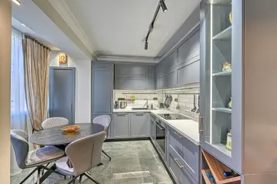 a kitchen with blue cabinets and a table and chairs at A new sense of home in Sofia