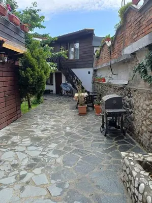 a stone courtyard with a building and a house at Студио в близост до църквата и центъра на града in Bansko