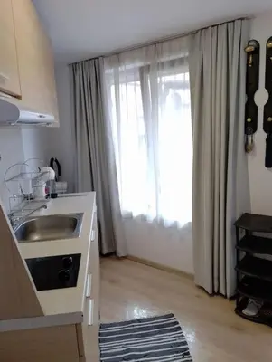 a kitchen with a sink and a large window at Студио в близост до църквата и центъра на града in Bansko