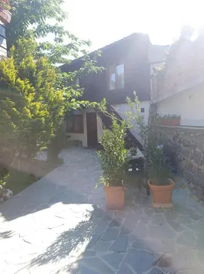 a house with two potted plants in front of it at Студио в близост до църквата и центъра на града in Bansko