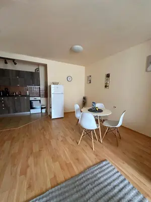 a living room with a table and chairs and a refrigerator at Nice, Spacious and Cozy Apartment in Sofia