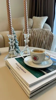 a cup of coffee and a book on a table at High End Elegant Living & Free Parking in Sofia