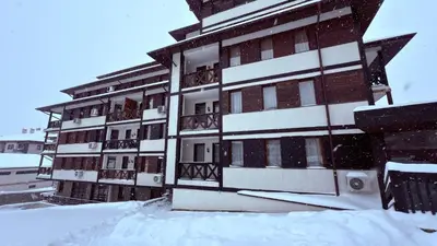 a building covered in snow in front at Florimont Heights Apart Complex in Bansko