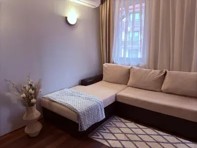 a living room with a couch and a window at Florimont Heights Apart Complex in Bansko